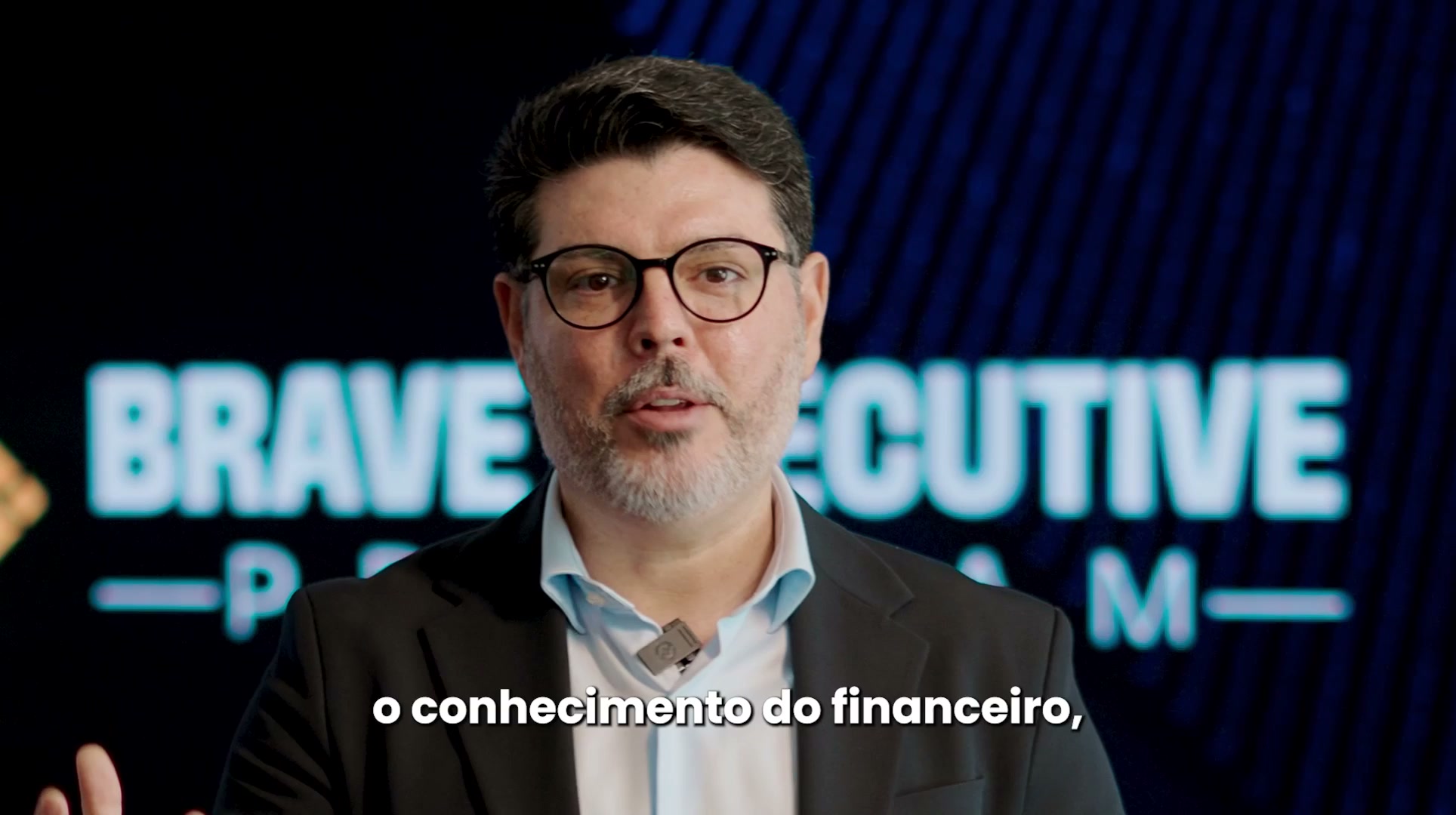 Cena do vídeo oficial do BEP, com um apresentador diante da identidade do programa.